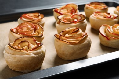 Photo of Tray with freshly baked apple roses, closeup view. Beautiful dessert