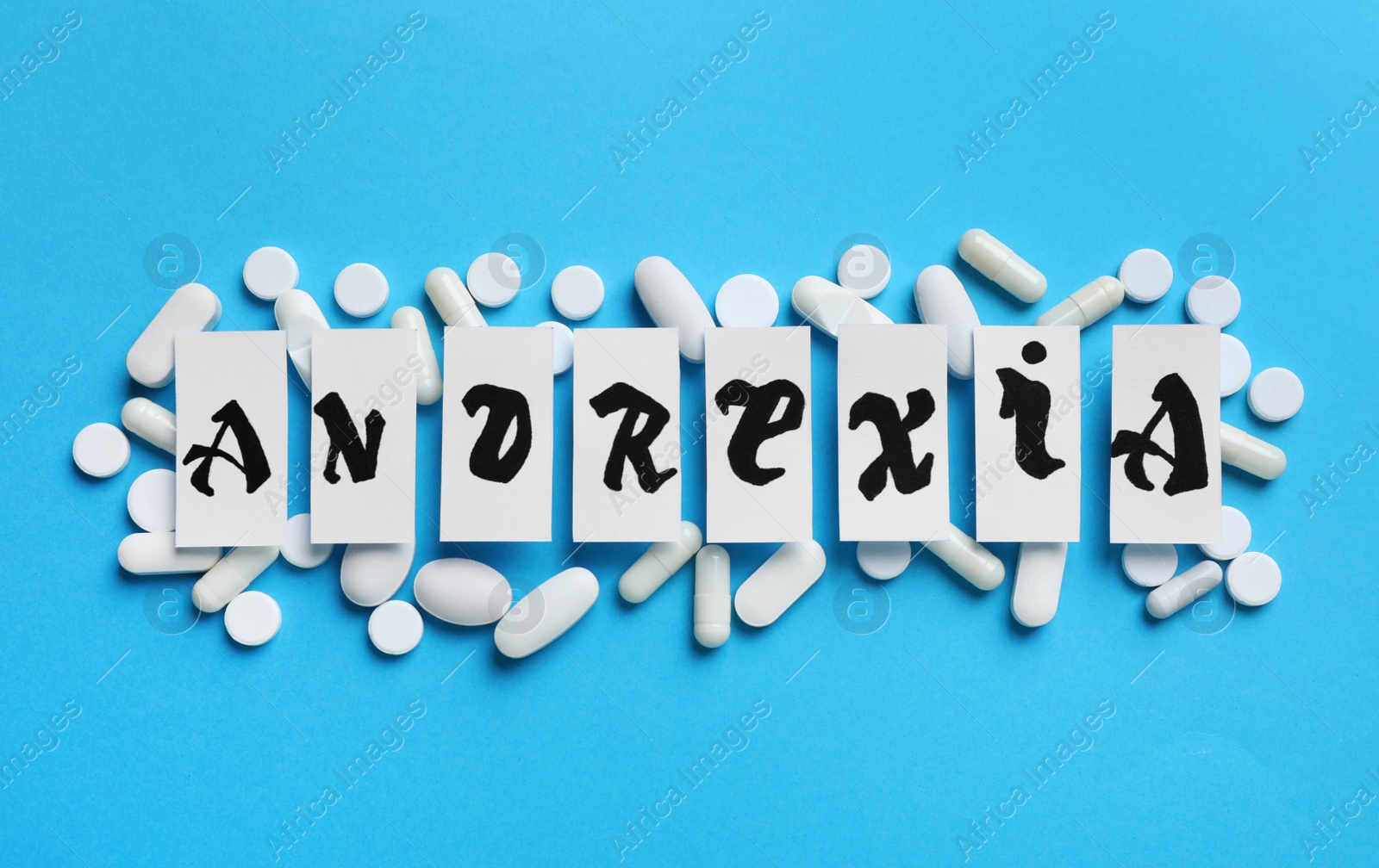 Photo of Pills and word Anorexia made of paper pieces on light blue background, flat lay