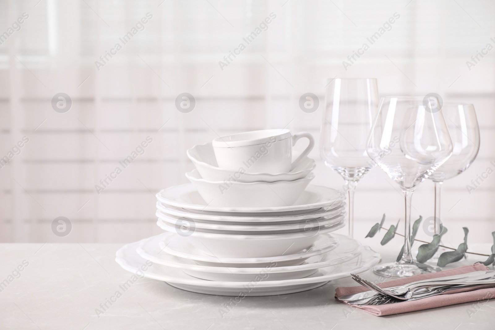 Photo of Set of clean tableware on light grey marble table