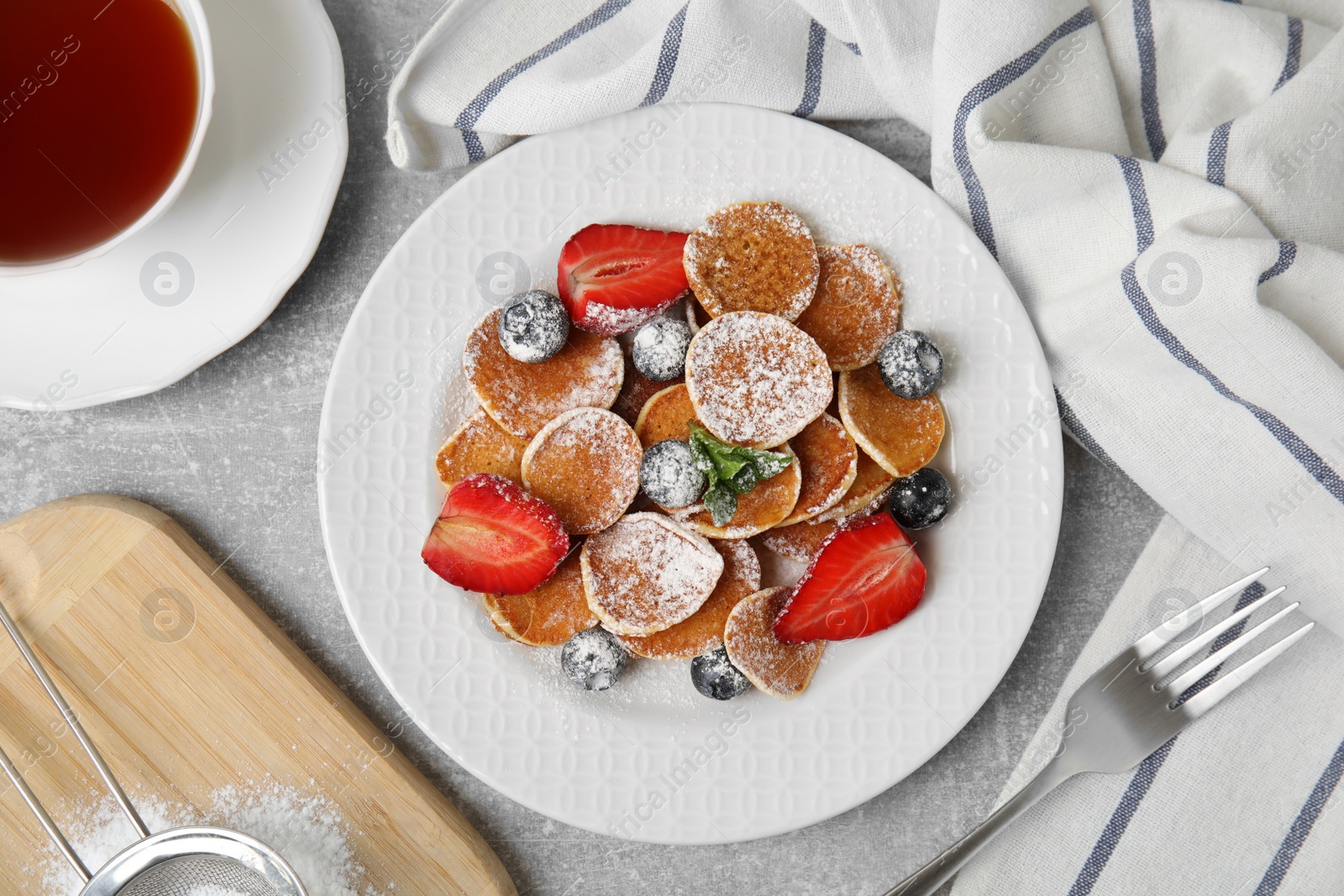 Photo of Cereal pancakes with berries served on light grey table, flat lay