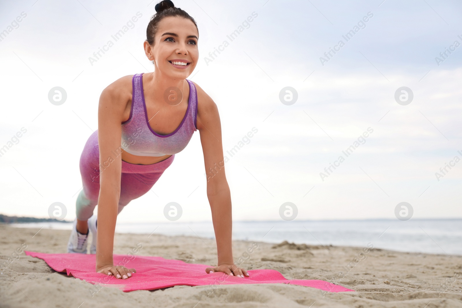 Photo of Young woman doing plank exercise on beach, space for text. Body training
