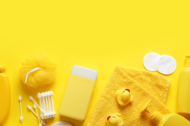 Photo of Flat lay composition with baby cosmetic products on yellow background