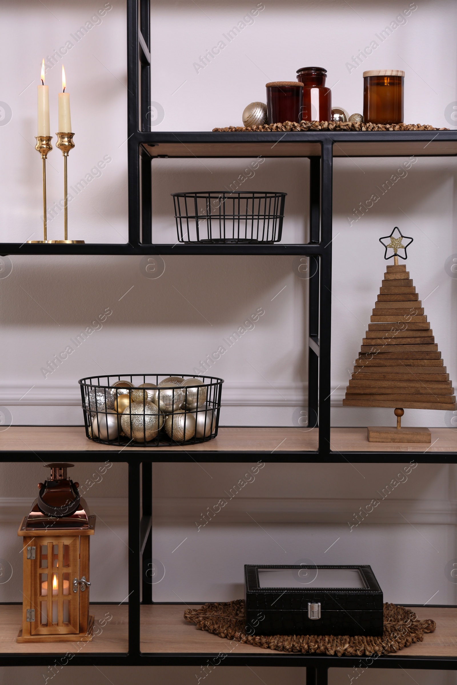 Photo of Stylish shelving unit with different decor near white wall indoors. Interior design