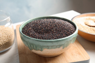 Photo of Bowl with raw black quinoa on table