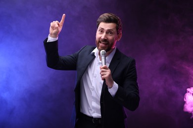 Photo of Emotional man with microphone singing in neon lights