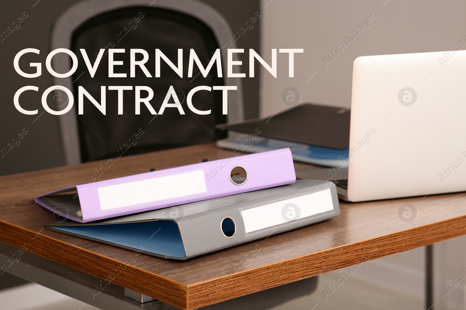 Image of Government contract. File folders and laptop on wooden table in office