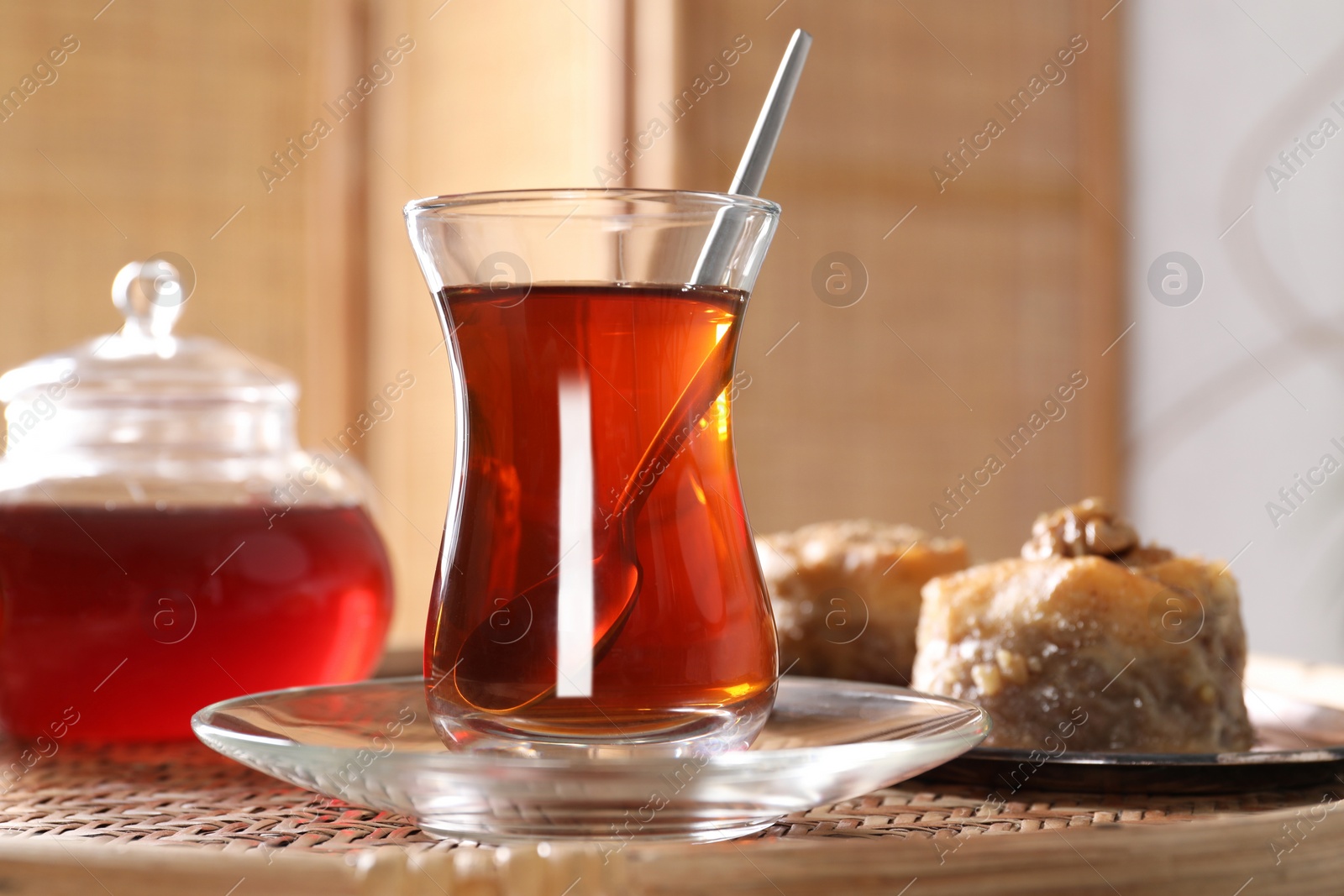 Photo of Traditional Turkish tea in glass on wicker table, closeup