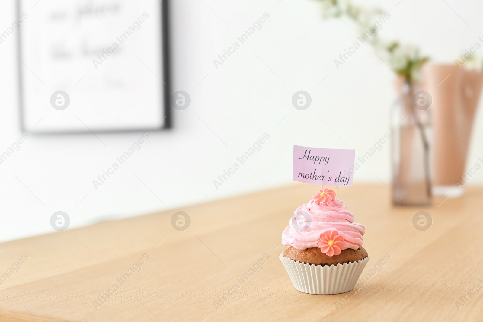 Photo of Topper with words HAPPY MOTHER'S DAY in cupcake on table