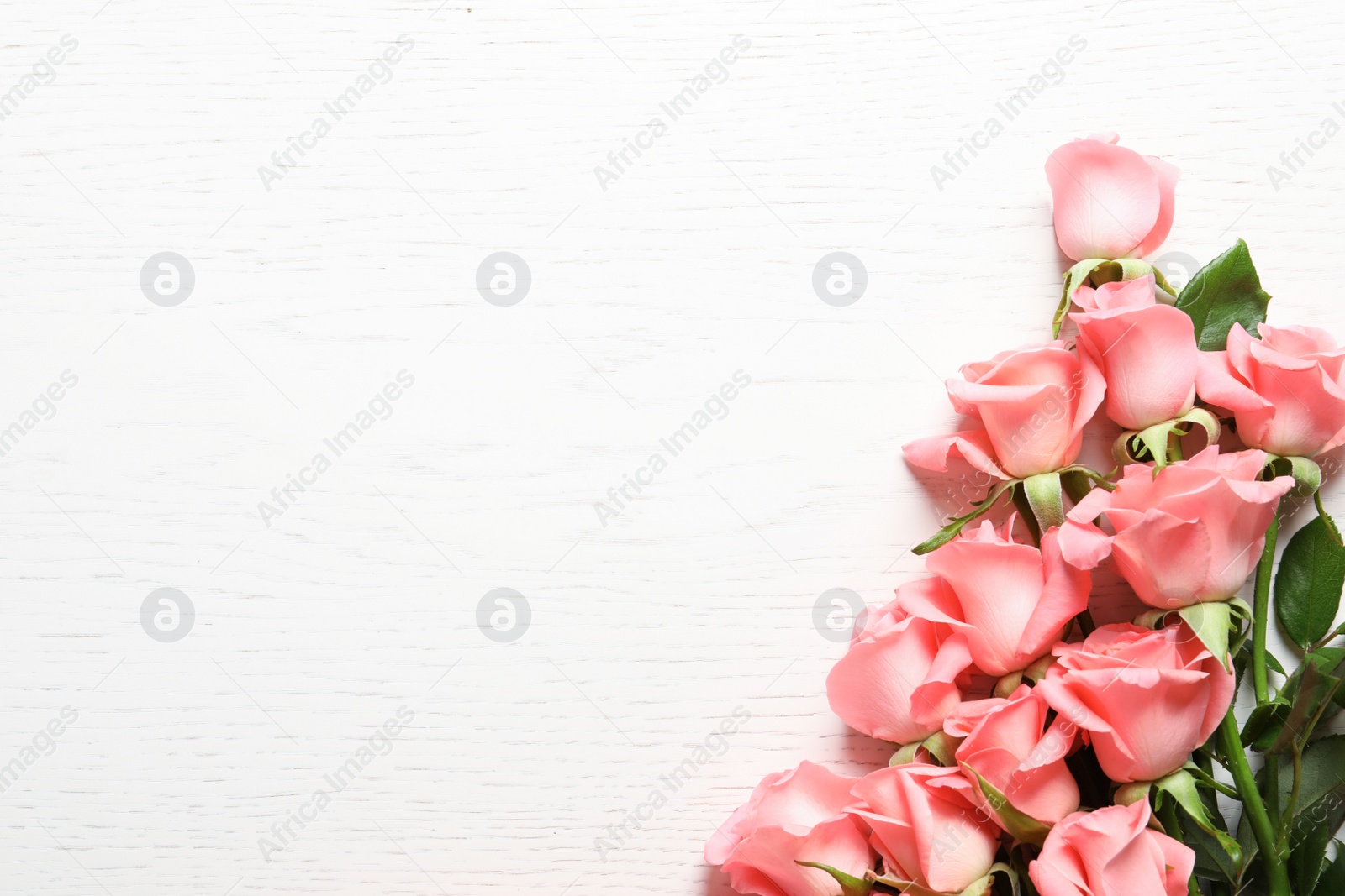 Photo of Beautiful roses on wooden table