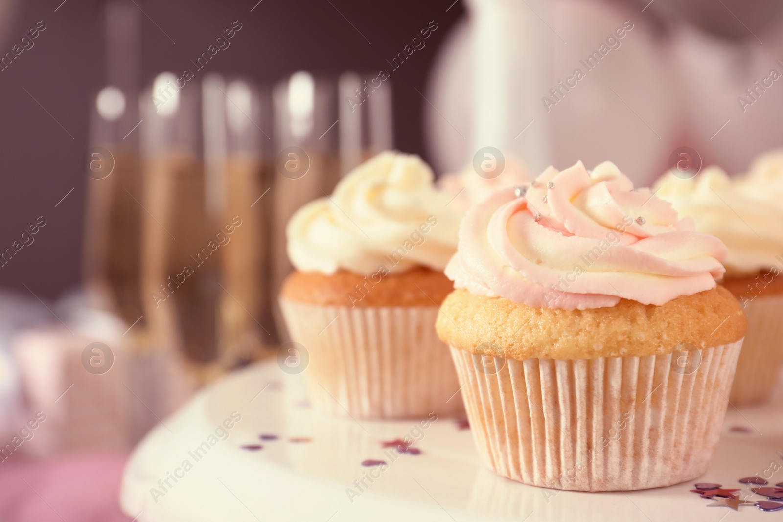 Photo of Stand with cupcakes on table, closeup. Space for text