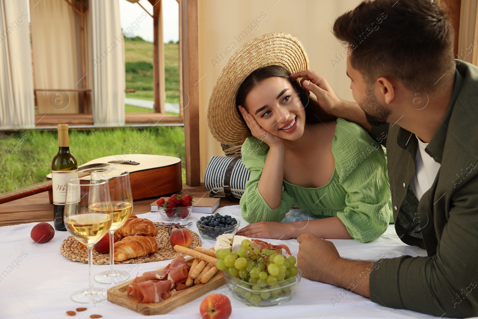 Photo of Romantic date. Beautiful couple spending time together during picnic in wooden gazebo