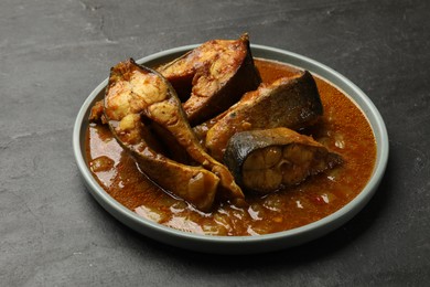 Photo of Tasty fish curry on grey textured table,closeup. Indian cuisine