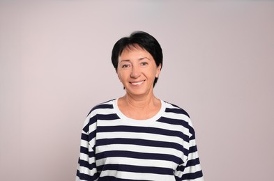 Photo of Portrait of smiling senior woman on light grey background