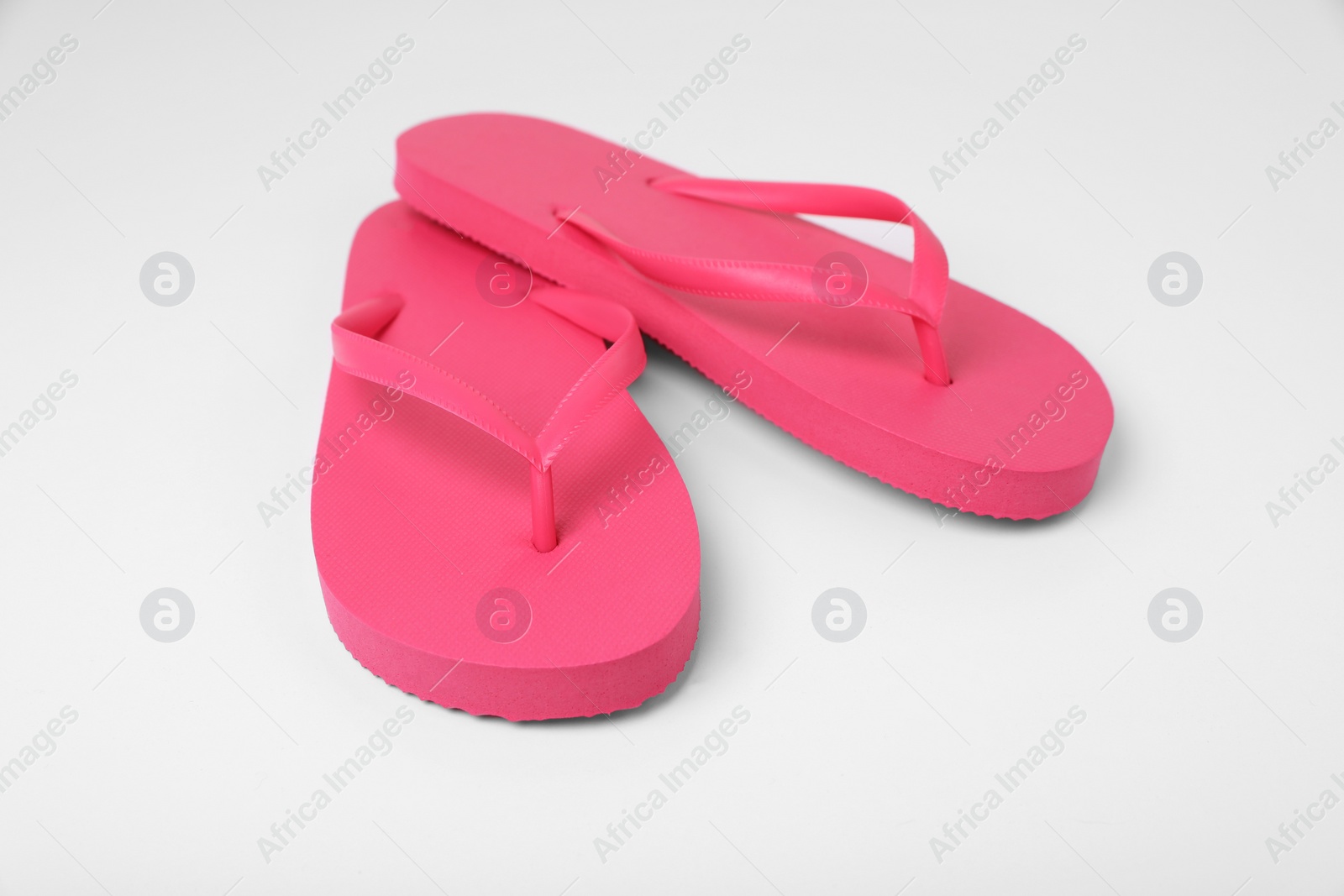 Photo of Stylish pink flip flops on white background