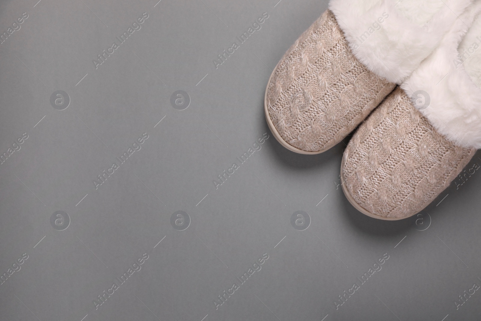 Photo of Pair of beautiful soft slippers on grey background, top view. Space for text