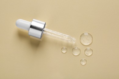 Photo of Pipette with samples of cosmetic serum on beige background, flat lay