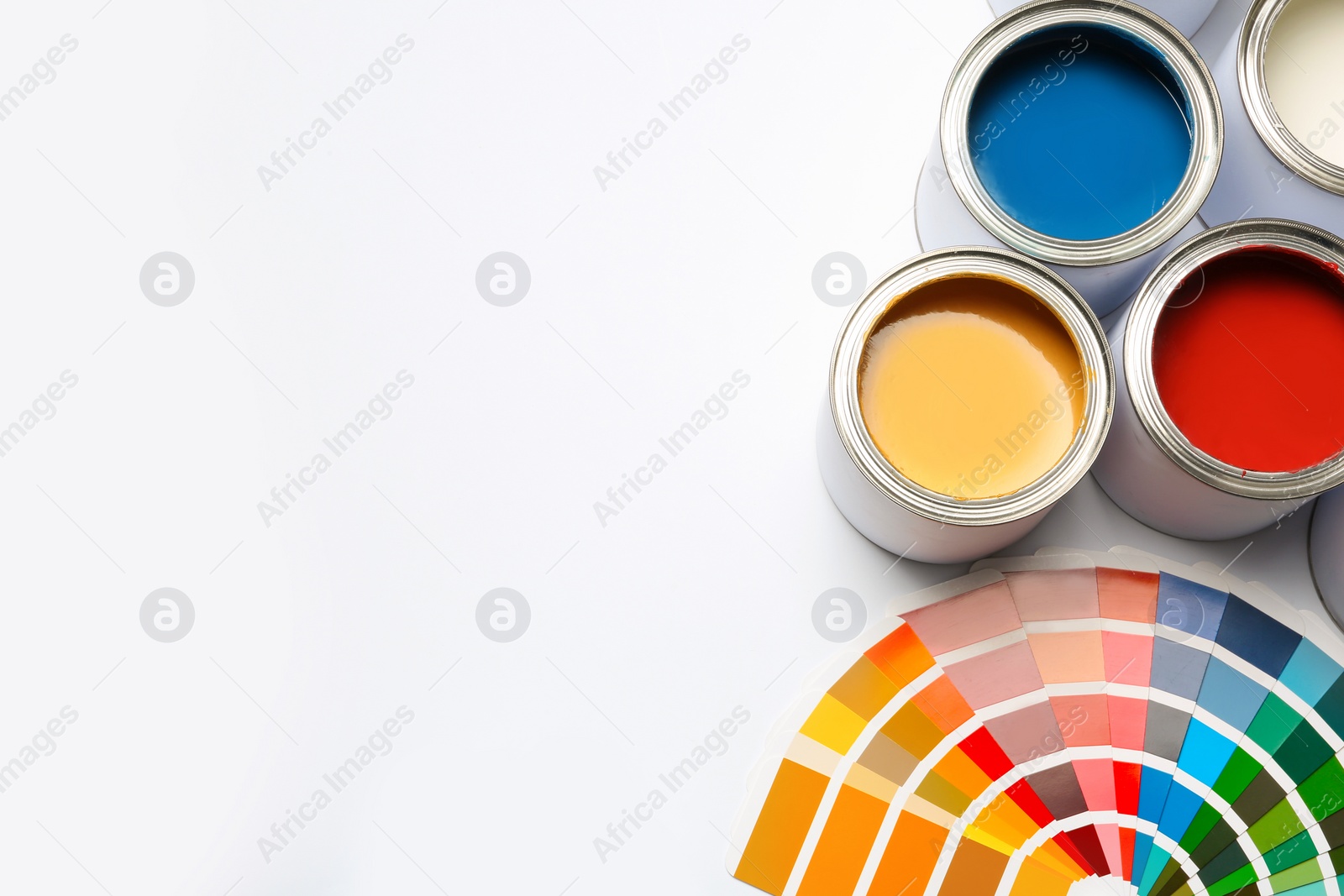 Photo of Different paint cans and color palette on white background, top view. Space for text
