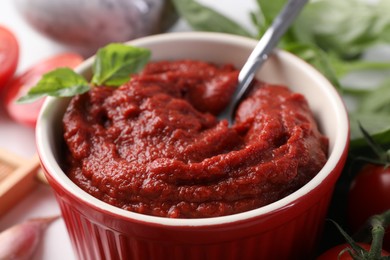 Photo of Tasty tomato paste in bowl on table, closeup