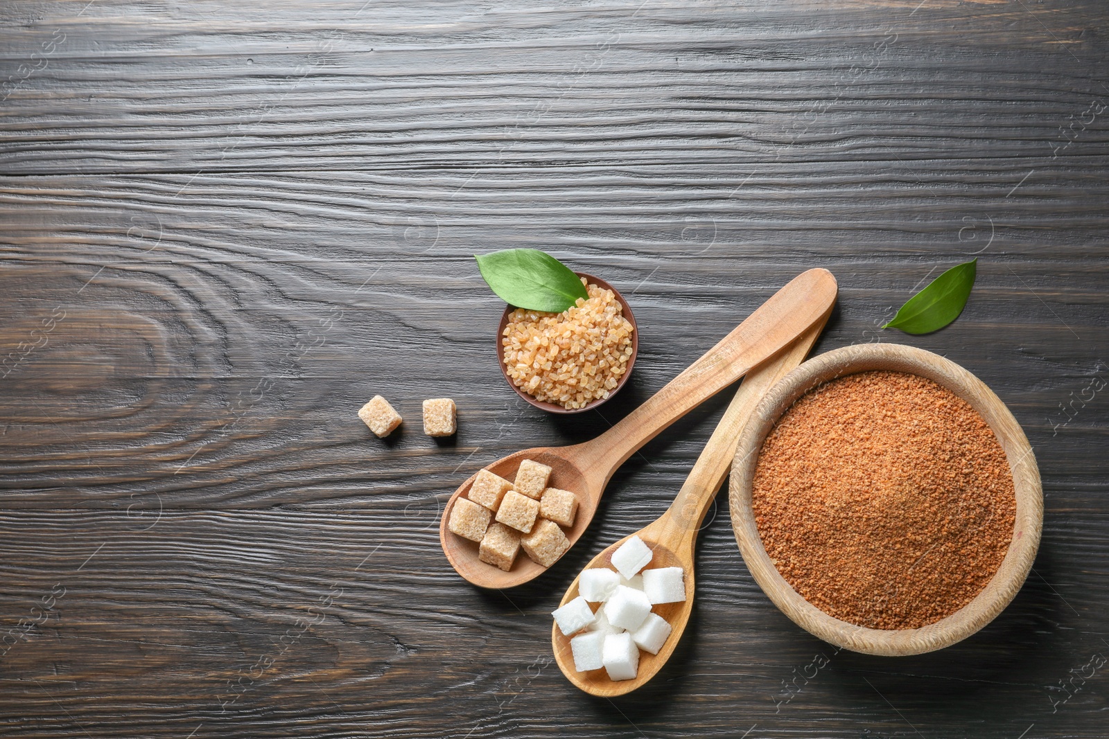 Photo of Composition with various kinds of sugar on wooden background, top view