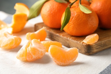 Photo of Ripe tangerines on table, closeup. Citrus fruit