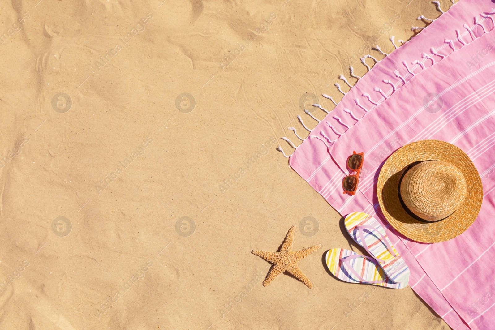 Photo of Flat lay composition with stylish beach accessories on sand. Space for text