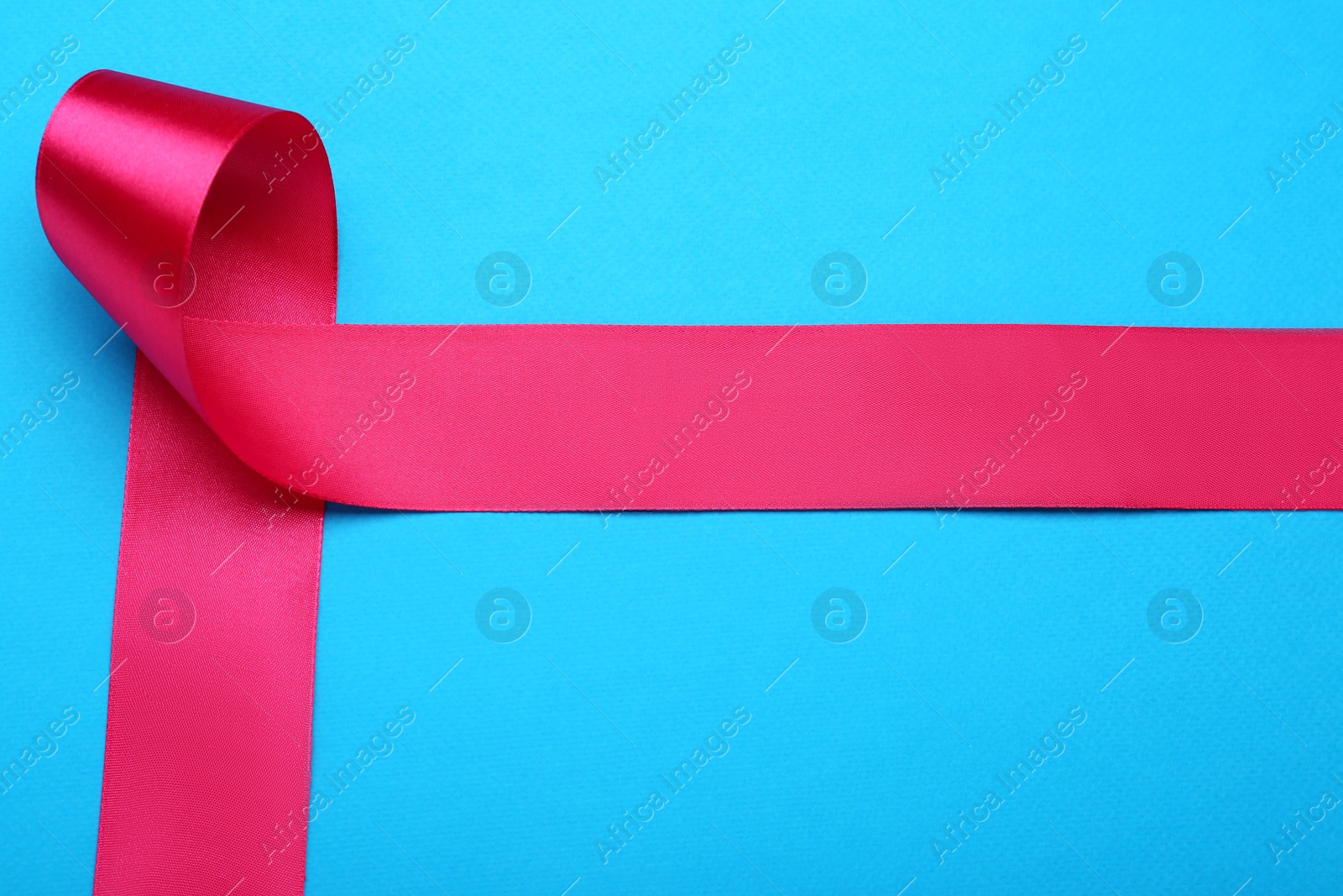 Photo of Beautiful pink ribbon on light blue background, top view