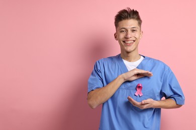 Photo of Mammologist with pink ribbon on color background, space for text. Breast cancer awareness