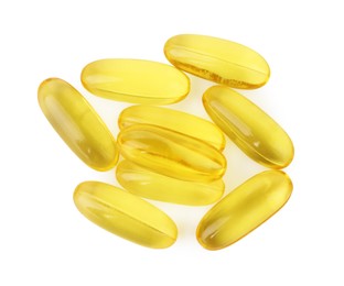 Photo of Many yellow vitamin capsules isolated on white, top view