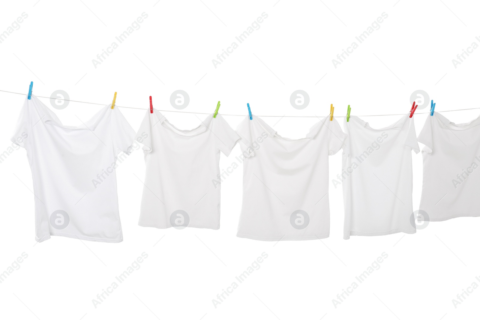 Photo of Many t-shirts drying on washing line isolated on white