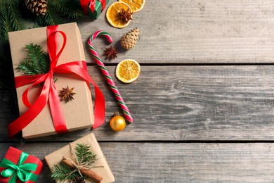 Photo of Flat lay composition with beautiful gift boxes and Christmas decorations on wooden table. Space for text