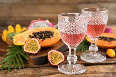 Delicious exotic fruits and wine on wooden table