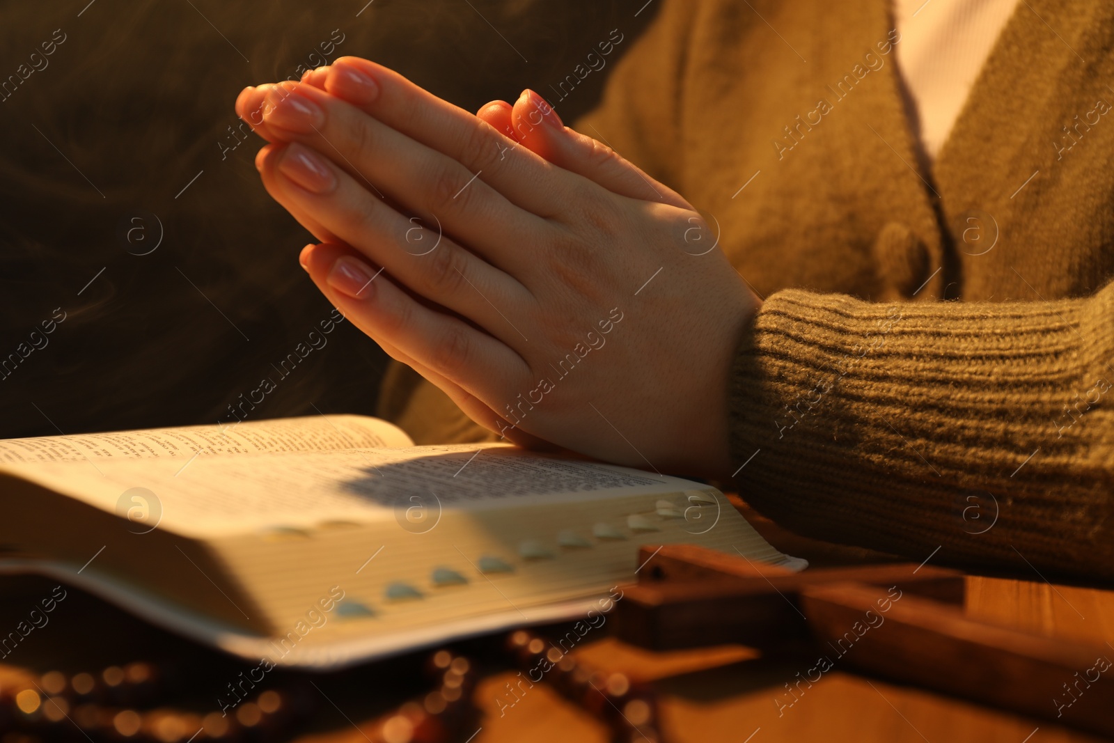 Photo of Woman with Bible praying at table, closeup