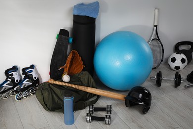 Photo of Many different sports equipment near wall indoors