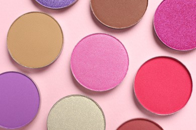 Photo of Different beautiful eye shadows on pink background, flat lay