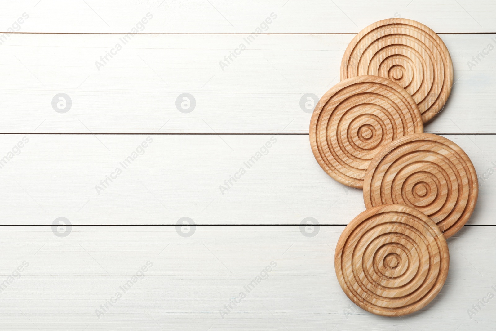 Photo of Stylish wooden cup coasters on white table, top view. Space for text