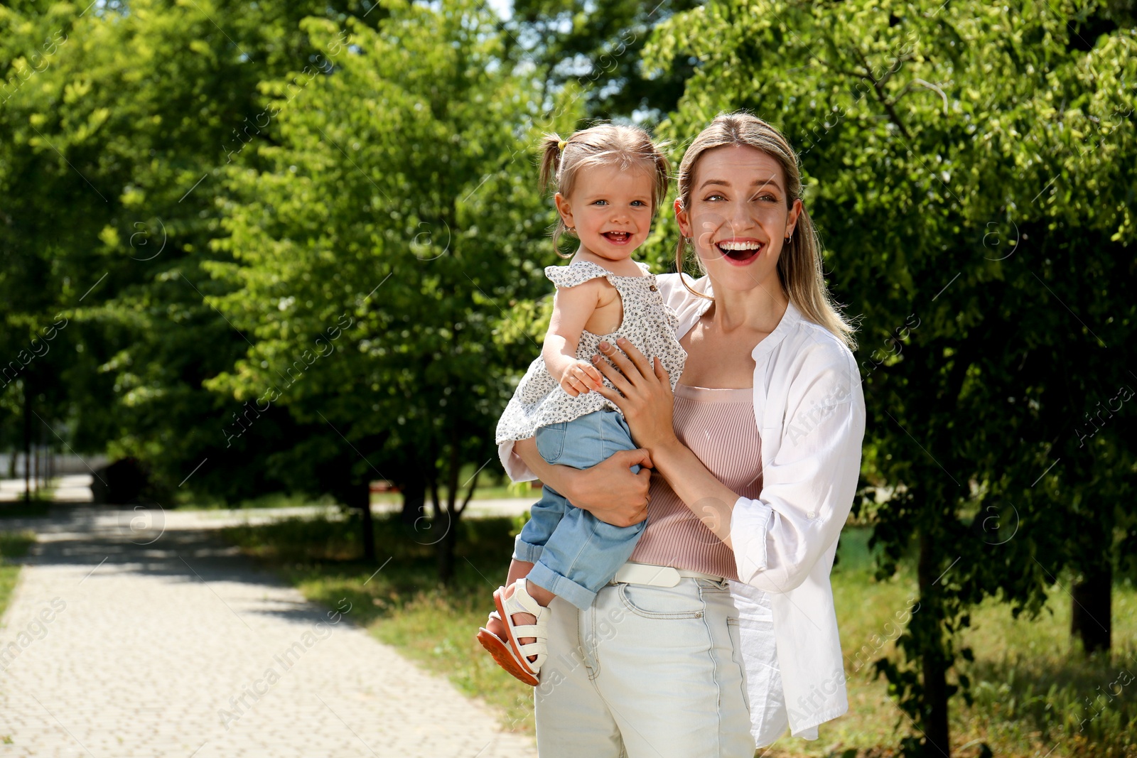 Photo of Happy mother with her daughter spending time together in park. Space for text