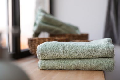 Photo of Clean soft towels on windowsill in bathroom