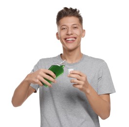 Young man with mouthwash on white background