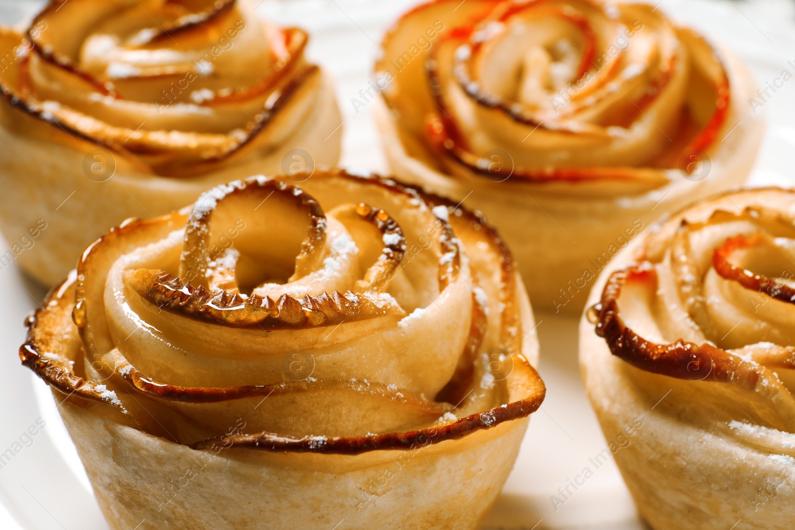 Photo of Freshly baked apple roses on plate, closeup. Beautiful dessert