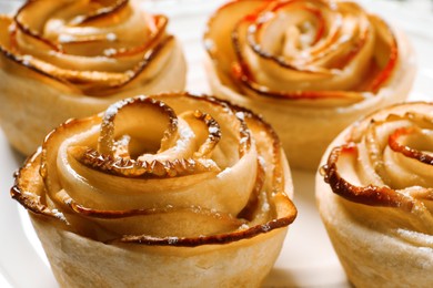 Photo of Freshly baked apple roses on plate, closeup. Beautiful dessert