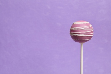 Photo of Bright delicious cake pop on color background. Space for text