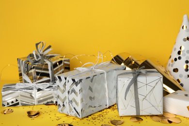 Photo of Gift boxes and birthday decor on yellow background