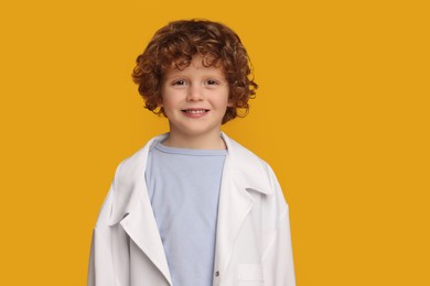 Photo of Portrait of little boy in medical uniform on yellow background