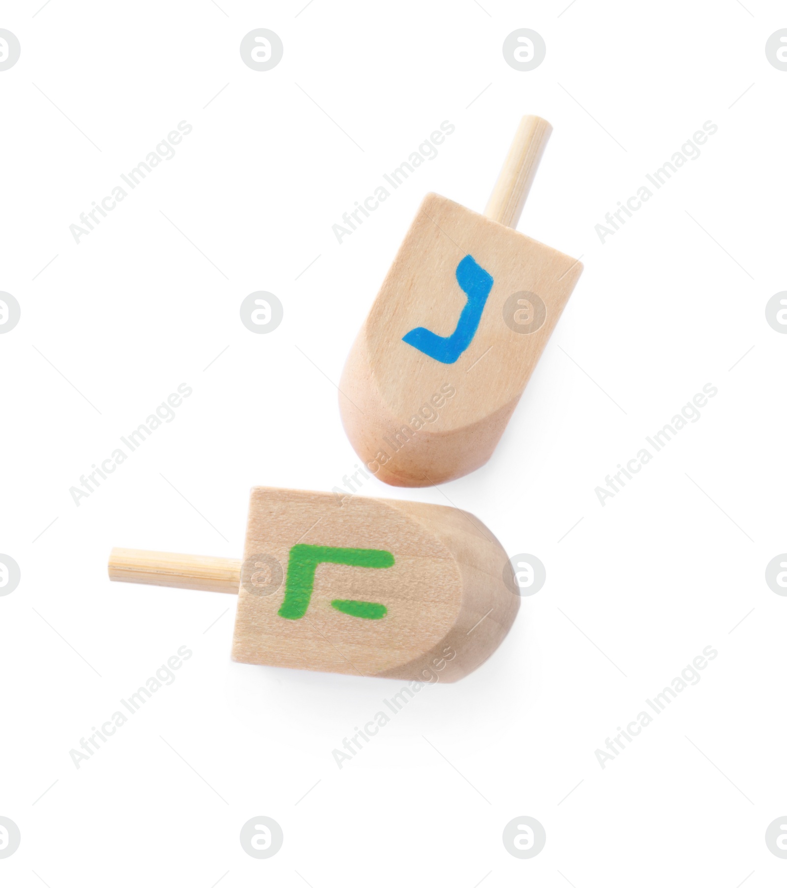 Photo of Wooden Hanukkah traditional dreidels with letters Nun and He on white background, top view
