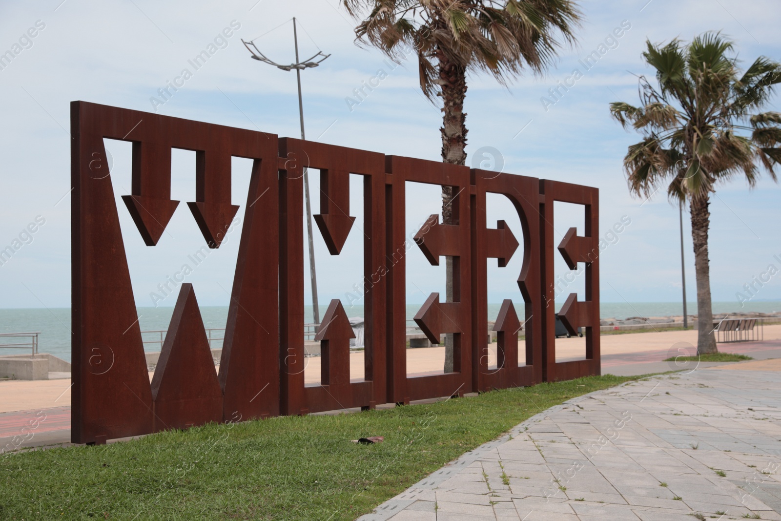 Photo of Batumi, Georgia - June 24, 2022: Beautiful art installation with word WHERE and palm trees near sea