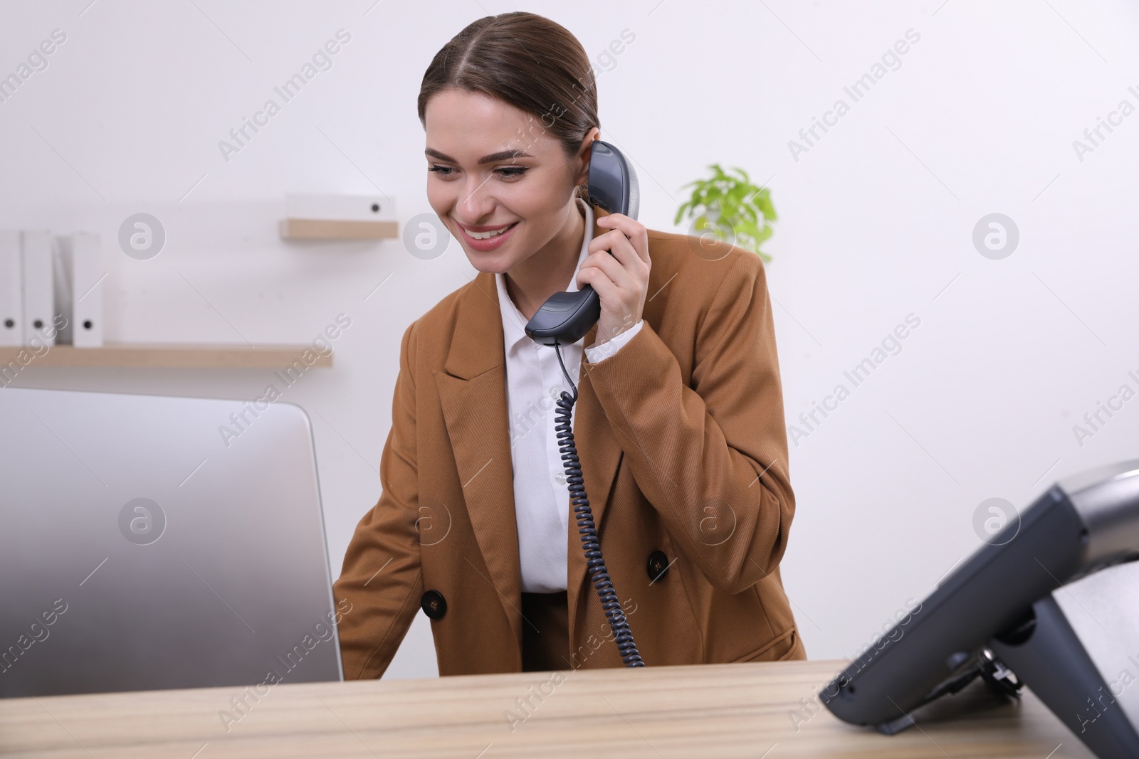 Photo of Female receptionist talking on phone at workplace