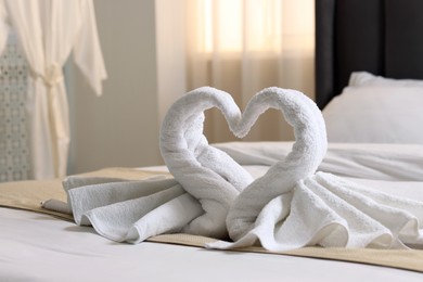 Photo of Honeymoon. Swans made of towels on bed in room