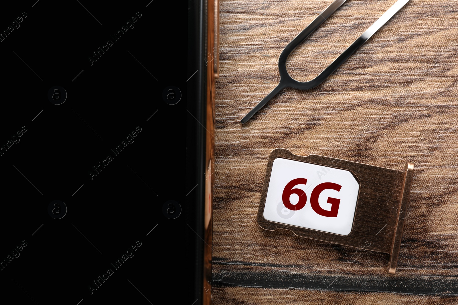 Photo of 6G technology, Internet concept. SIM card in tray and smartphone on wooden table, closeup