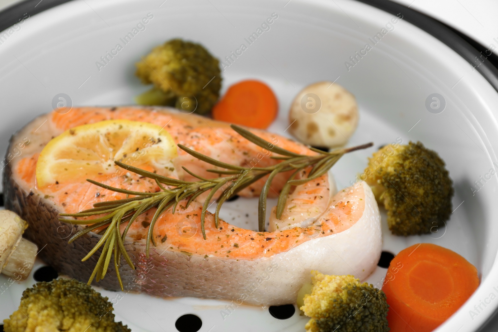 Photo of Salmon steak with garnish in multi cooker, closeup