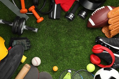 Photo of Frame of different sports equipment on green grass, flat lay. Space for text